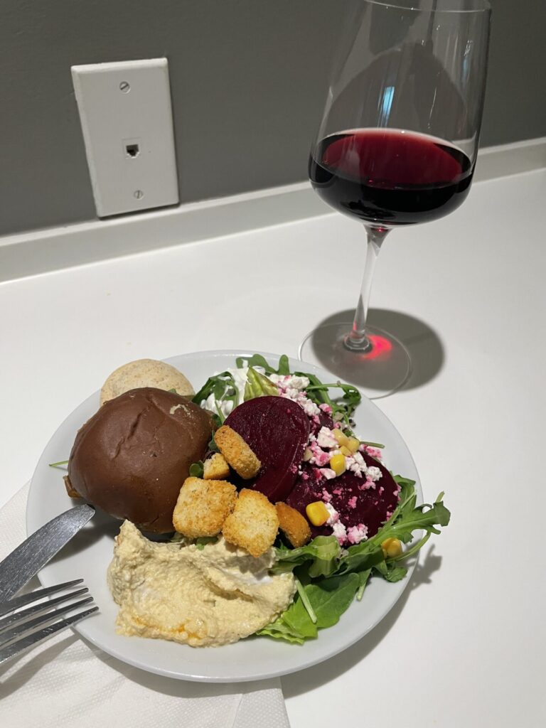 salad sandwich and red wine plate put together with food from the avianca tap lounge at mia